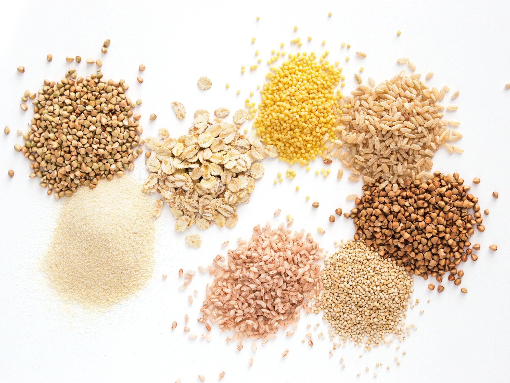 Assorted grains including millet, oats and quinoa arranged in small heaps